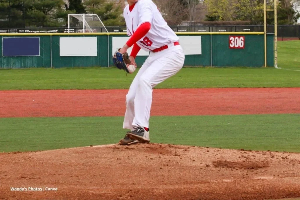 estrategias de pitcheo – lanzador de béisbol con uniforme blanco y rojo preparándose para lanzar